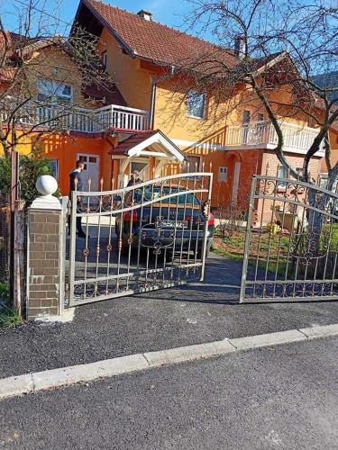 a gate in front of a house with a car at Apartment In The Nature in Ilidza