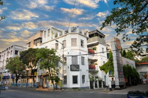 a white building on the side of a street at The Corner Courtyard in Kolkata