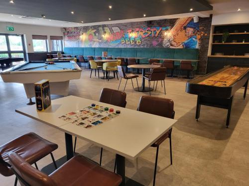 a restaurant with two tables and a pool table at The Willows Training Centre in Wyboston