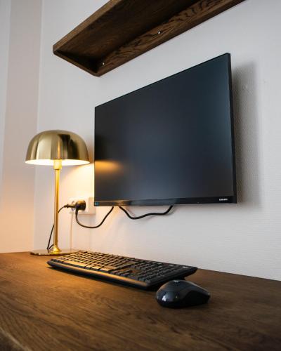 a computer monitor and a keyboard and mouse on a desk at Hotel Phønix Hjørring in Hjørring