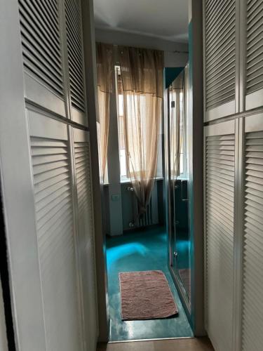 a walk in closet with a mirror and a rug at Bon Bon il Morelli in pieno centro no ztl in Asti