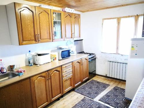 eine Küche mit Holzschränken und einer Spüle in der Unterkunft Alpina66 in Jieţ