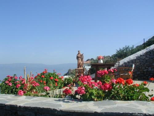 eine Statue in einem Garten mit Blumen in der Unterkunft Hydra Erato in Hydra