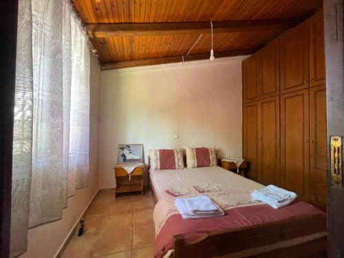 una camera da letto con un letto e un soffitto in legno di Μονοκατοικία Στο Λουτρακι a Loutraki