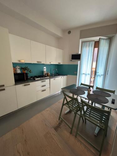 a kitchen with white cabinets and a table and chairs at Bon Bon il Morelli in pieno centro no ztl in Asti