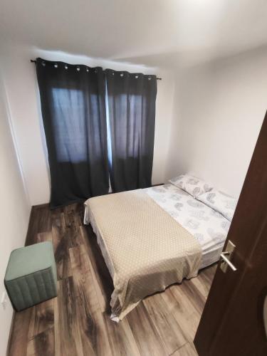 a bedroom with a bed and a black curtain at Apartament Luna in Jurilovca
