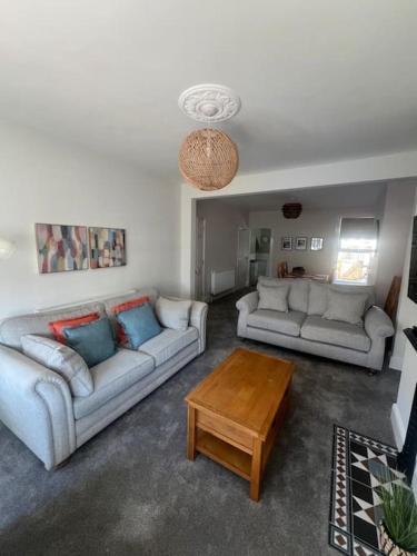 a living room with two couches and a coffee table at Stylish House Near Beach in Pakefield