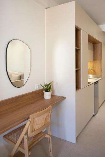 a room with a desk with a mirror and a chair at CK Apartments in Nydri