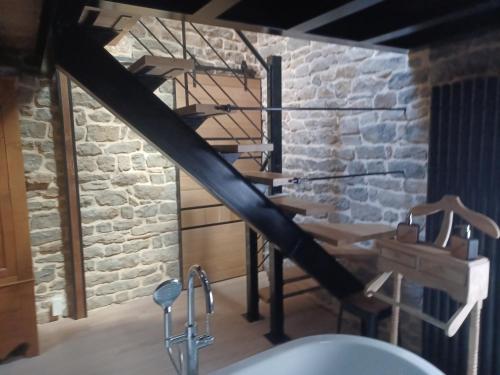 La salle de bains est pourvue d'un lavabo et d'un mur en briques. dans l'établissement Chambre la cozanne, à Cheilly-lès-Maranges