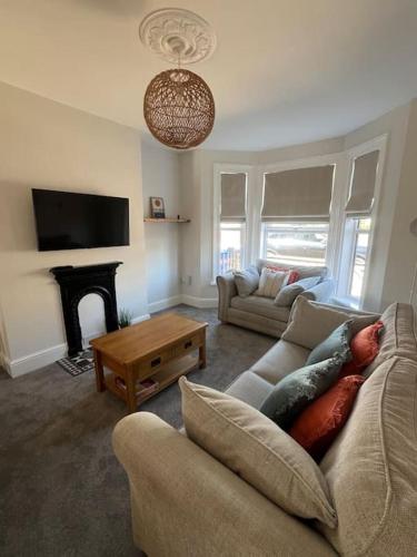 a living room with a couch and a fireplace at Stylish House Near Beach in Pakefield