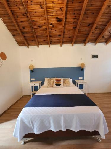 a bedroom with a blue and white bed and wooden ceilings at Yedi Butik Hotel in Kemer