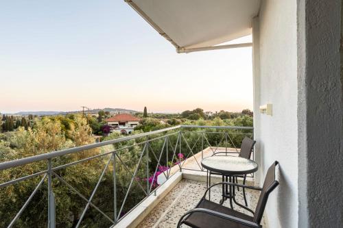 a balcony with a table and chairs and a view at Skafidia Garden Gem - Mirtia Fully Equipped Home in Áyios Ilías