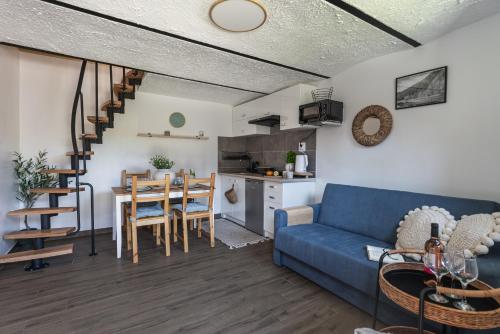 a living room with a blue couch and a kitchen at Pokoje Gościnne Malinówka in Krościenko
