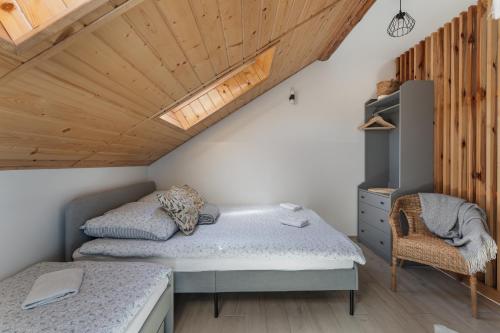 a bedroom with two beds and a wooden ceiling at Pokoje Gościnne Malinówka in Krościenko