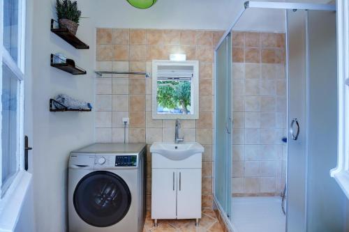 a bathroom with a washing machine and a sink at Ailanto in Lygia