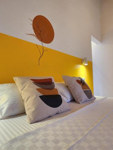 a bed with two pillows and a tree on the wall at Yedi Butik Hotel in Kemer