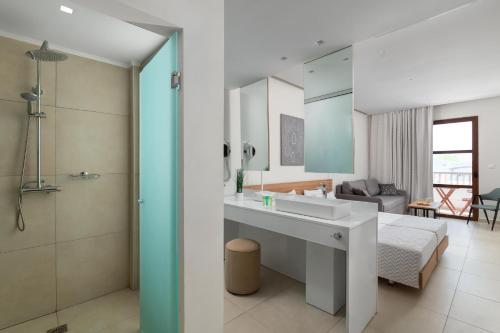 a bathroom with a sink and a bedroom with a bed at Costa Lindia Blue Star - Adults Only in Lartos