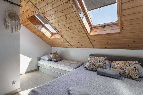 a bedroom with a bed and two windows at Pokoje Gościnne Malinówka in Krościenko