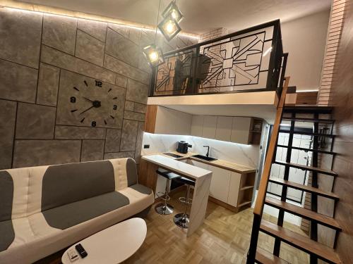 a room with a loft bed with a desk and a clock at Studio Lazur in Burgas