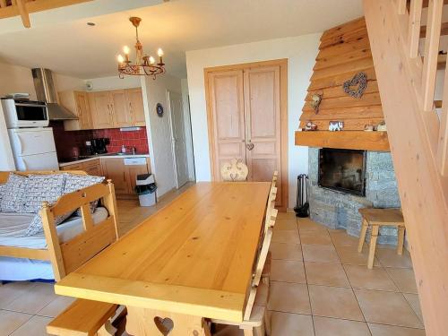 Il dispose d'une cuisine et d'un salon avec une table et une cheminée. dans l'établissement Duplex 8pers avec Balcon Sud, Cheminée, WIFI Gratuit - Animaux admis - Parking & Ménage en option - FR-1-393-63, à Saint-Michel-de-Chaillol