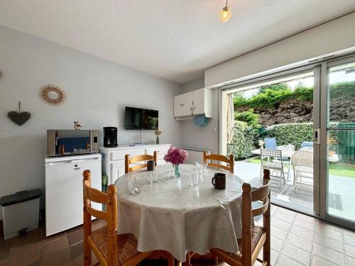 une cuisine et une salle à manger avec une table et une cuisine, ainsi qu'une table et des chaises dans l'établissement Appartement 2 pièces avec jardin, proche plage de Beaumer, Carnac - 4 pers. - FR-1-377-19, à Carnac
