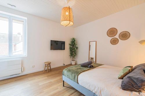 une chambre avec un lit et une télévision à écran plat dans l'établissement L'éclat - Calme et proche gare, à Reims