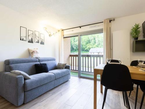 un salon avec un canapé bleu et une table dans l'établissement Appartement calme Saint Lary 4 personnes, proche centre, wifi inclus - FR-1-296-284, à Saint-Lary-Soulan