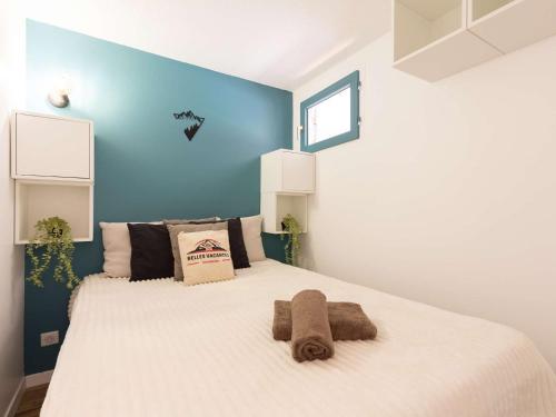 - une chambre avec un grand lit blanc et un mur bleu dans l'établissement Appartement calme Saint Lary 4 personnes, proche centre, wifi inclus - FR-1-296-284, à Saint-Lary-Soulan