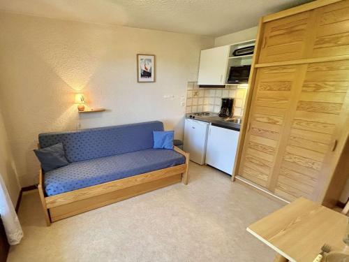 une petite pièce avec un canapé bleu dans une cuisine dans l'établissement Studio confortable avec balcon, proche des pistes - 2 couchages à Demi-Quartier - FR-1-597-18, à Demi-Quartier