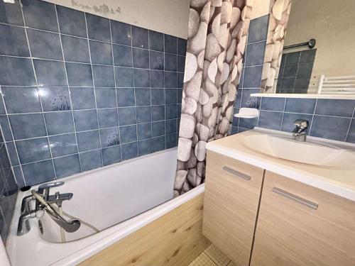 une salle de bain avec une baignoire et un lavabo dans l'établissement Studio confortable avec balcon, proche des pistes - 2 couchages à Demi-Quartier - FR-1-597-18, à Demi-Quartier