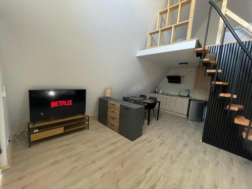 a living room with a television and a staircase at Domki w Dąbkach in Dąbki
