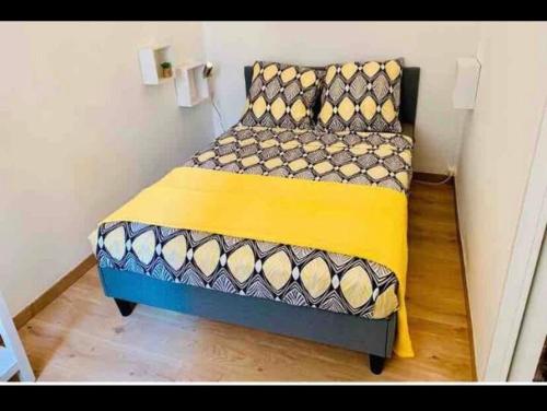 - 2 lits dans une petite chambre de couleur jaune et bleue dans l'établissement Appartement plage Catalan, à Marseille