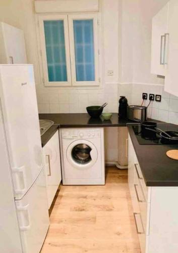 une cuisine blanche avec une machine à laver à l'intérieur dans l'établissement Appartement plage Catalan, à Marseille