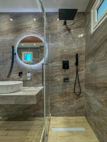 a bathroom with a shower and a sink and a mirror at VSP RENT ROOMS FUeGO in Sikia
