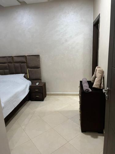 a bedroom with a bed and a chair in a room at Nador New in Nador