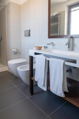 a bathroom with a sink and a toilet and towels at Hotel Napoleon in Torre Melissa