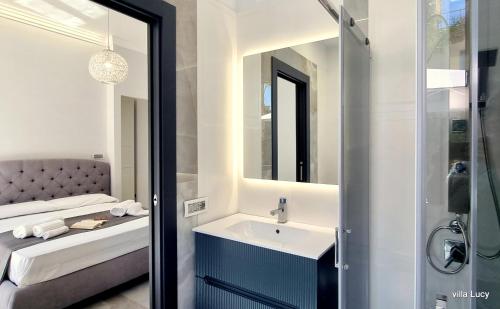 a bathroom with a sink and a bed and a mirror at Luxury villa Lucy with pool on front of beach of Donnalucata in Donnalucata