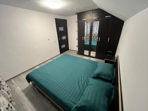 Habitación pequeña con cama verde. en Apartament Casa Dragoeni, en Târgu Jiu