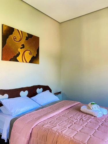 a bedroom with a large bed with a pink blanket at Pousada Cardeal Mota in Serra do Cipo