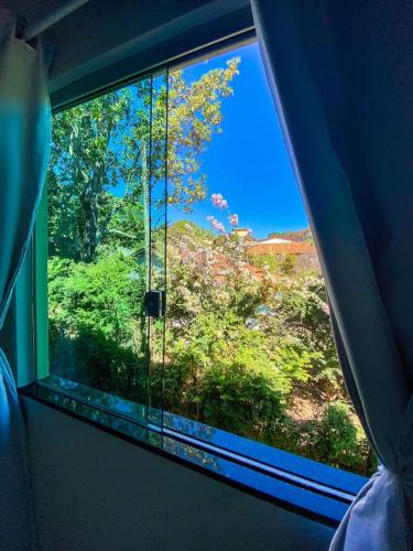 a window in a room with a view of a tree at Pousada Cardeal Mota in Serra do Cipo