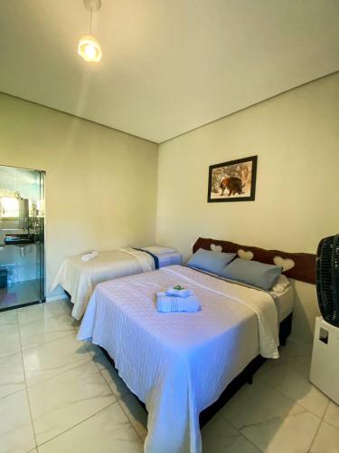 a bedroom with two beds with white sheets at Pousada Cardeal Mota in Serra do Cipo