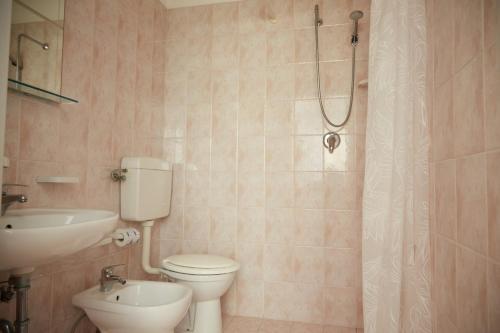 a bathroom with a toilet and a sink and a shower at Hotel ITALIACERVIA in Cervia
