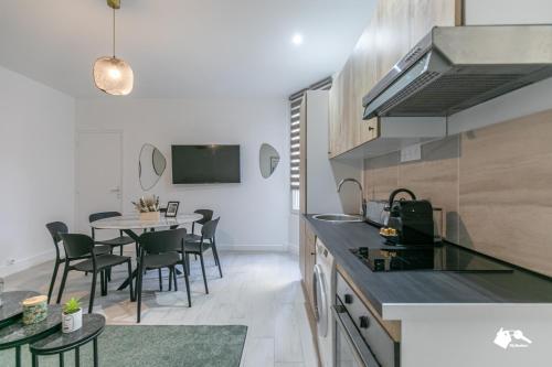 une cuisine et une salle à manger avec une table et des chaises dans l'établissement MBA-Splendide Appart Mowat Proche Château de Vincennes, à Vincennes