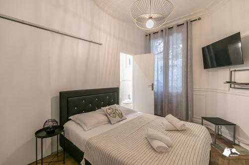 Un dormitorio con una cama con dos almohadas encima. en MBA-Splendide Appart Mowat Proche Château de Vincennes, en Vincennes