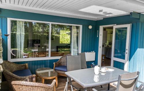 a screened porch with a table and chairs at 2 Bedroom Nice Home In Samsø in Samsø