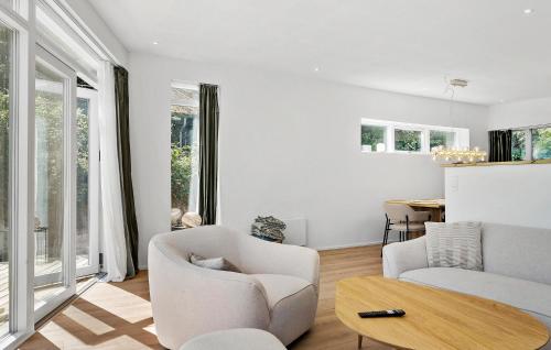 a living room with white furniture and a table at 4 Bedroom Beach Front Home In Børkop in Børkop