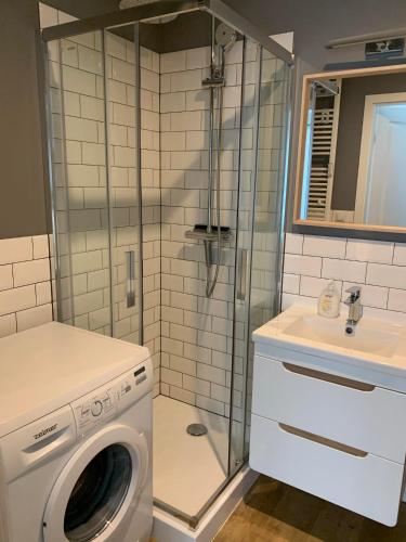 a bathroom with a washing machine and a sink at Przytulna kawalerka nad Jeziorem Długim darmowy parking i rowery in Olsztyn