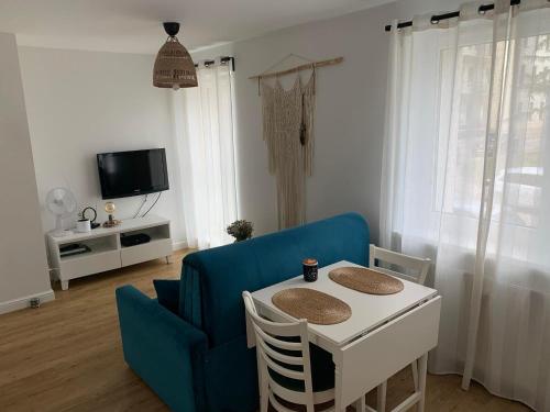 ein Wohnzimmer mit einem blauen Sofa und einem Tisch in der Unterkunft Przytulna kawalerka nad Jeziorem Długim darmowy parking i rowery in Olsztyn