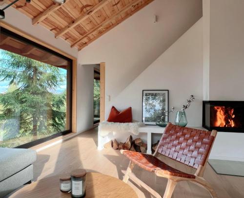 a living room with a couch and a chair at Forestia - Modern cabin with hot tub and sauna in Dealu Negru