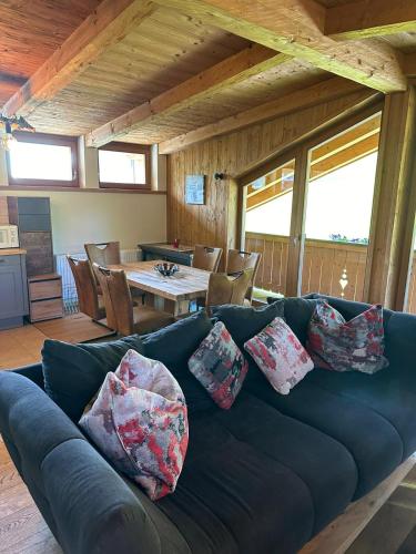 a living room with a blue couch and a table at Sportpension Enzian in Saalbach Hinterglemm